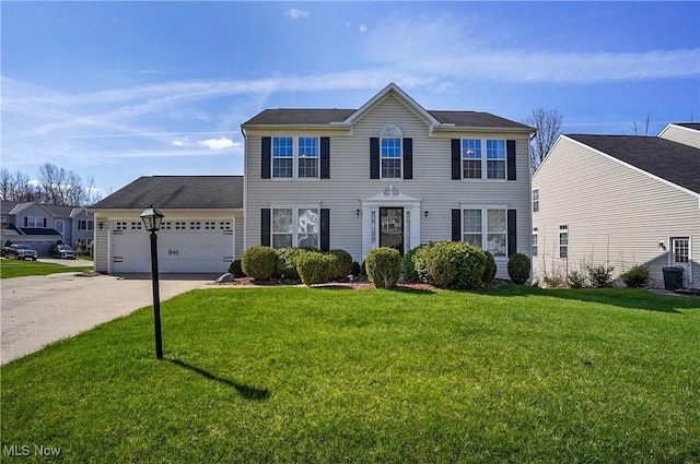 colonial house with a front yard, a garage, and concrete driveway