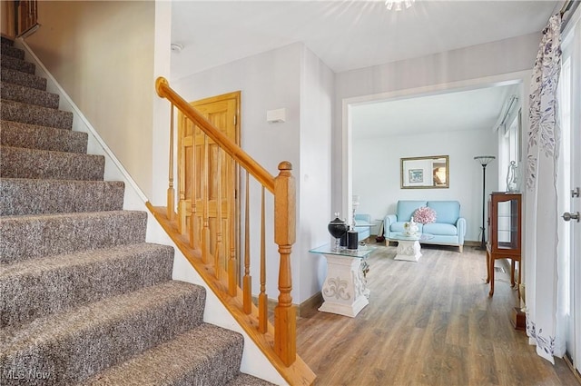 stairs featuring wood finished floors and baseboards