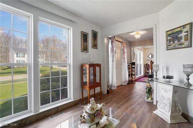 hallway featuring visible vents and dark wood finished floors
