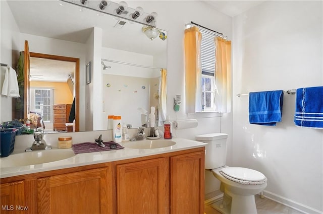 bathroom featuring double vanity, visible vents, a sink, and toilet