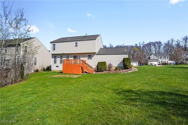 rear view of property with a yard, stairway, and a deck