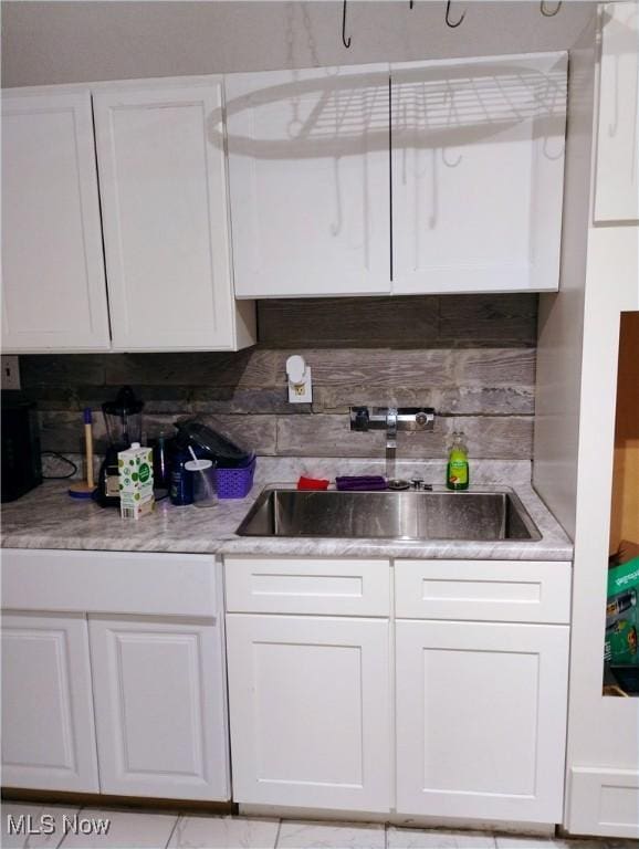 6010 Maurice Ave, Cleveland, OH 44127 - kitchen with decorative backsplash, a sink, and white cabinets