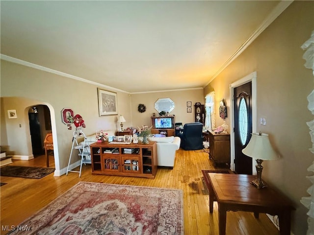 living room featuring crown molding, arched walkways, and hardwood / wood-style floors