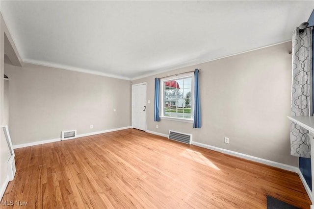unfurnished living room featuring light wood-style floors, visible vents, a stone fireplace, and baseboards