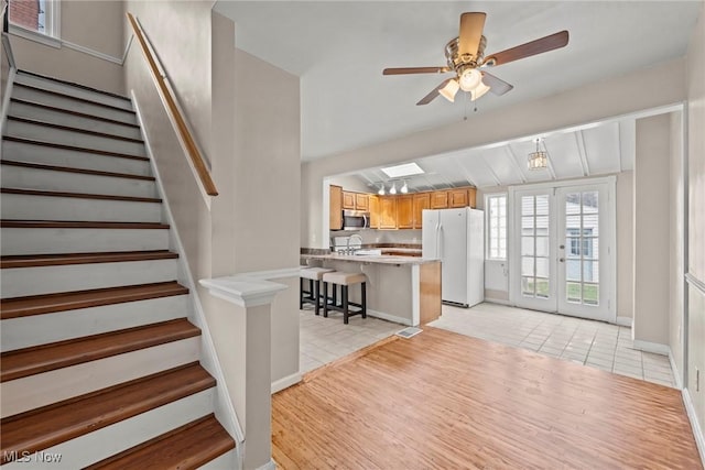 interior space featuring ceiling fan, light tile patterned flooring, stairs, french doors, and baseboards