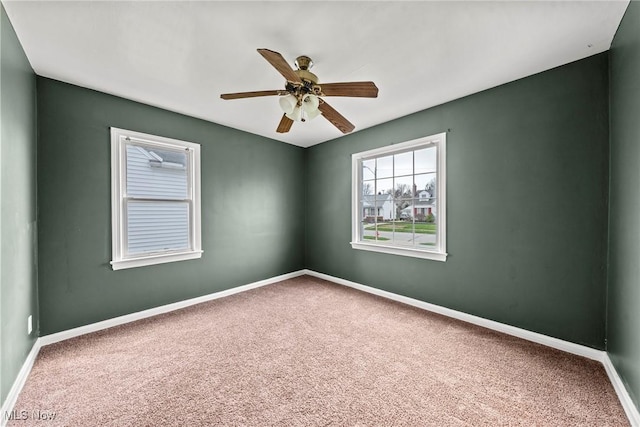 carpeted empty room with baseboards and ceiling fan