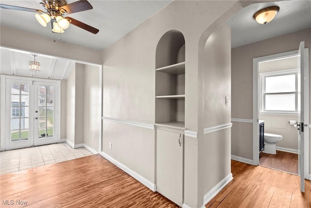 interior space with a wealth of natural light, light wood finished floors, and baseboards
