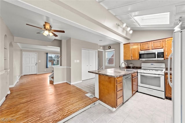 kitchen with a sink, a wealth of natural light, a peninsula, and stainless steel appliances