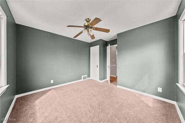 unfurnished bedroom with carpet flooring, baseboards, and visible vents
