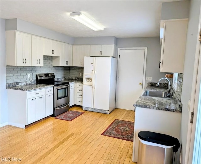 14864 Hayes Rd, Middlefield, OH 44062 - kitchen with white fridge with ice dispenser, stainless steel electric stove, a sink, light wood-type flooring, and backsplash