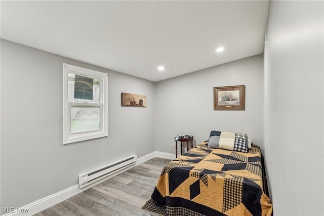 bedroom with a baseboard radiator, recessed lighting, wood finished floors, and baseboards