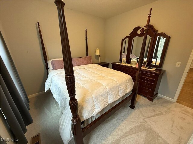 bedroom featuring visible vents, baseboards, and light colored carpet