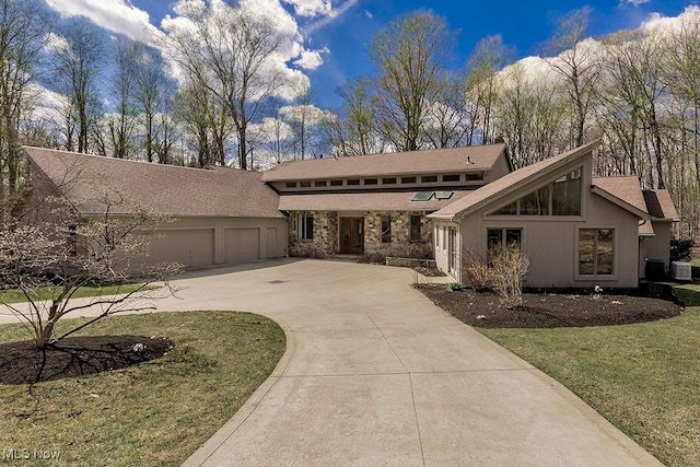 8740 Galloway Trl, Novelty, OH 44072 - mid-century home with a front yard, an attached garage, stone siding, driveway, and roof with shingles