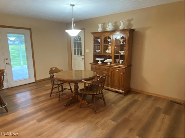 dining space featuring light wood finished floors and baseboards