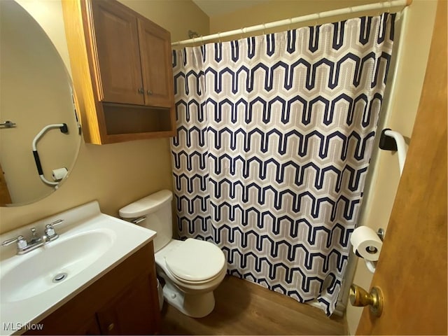 bathroom with toilet, curtained shower, vanity, and wood finished floors