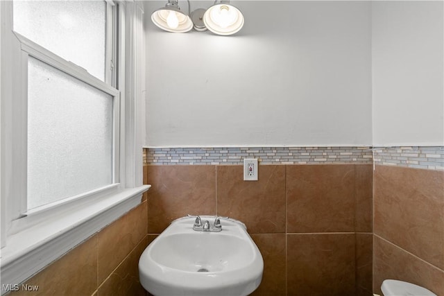 bathroom featuring tile walls and a sink