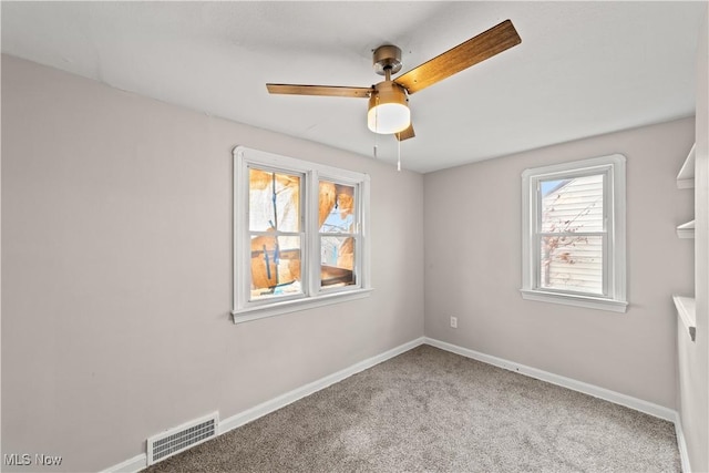 unfurnished room with carpet, baseboards, a ceiling fan, and visible vents