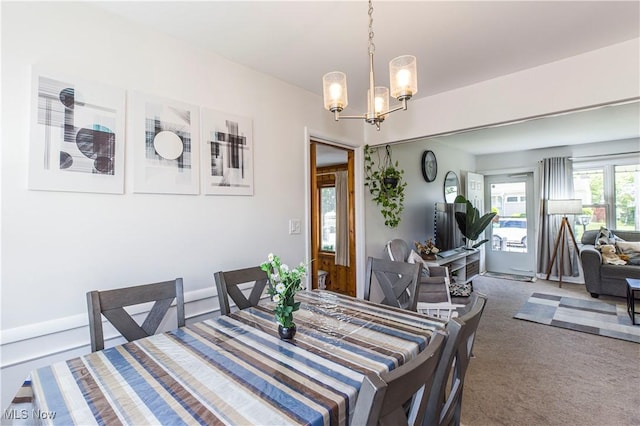 carpeted dining room with a chandelier