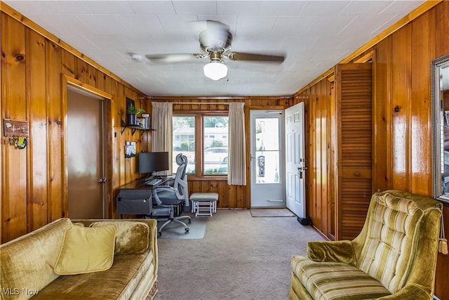 office area with wooden walls, carpet flooring, and ceiling fan