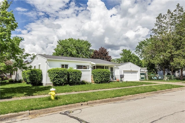 view of front of property with an attached garage, a front yard, and driveway