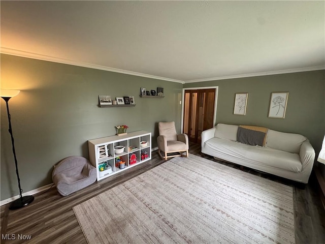 living room with baseboards, crown molding, and wood finished floors