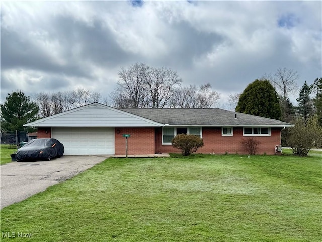ranch-style home with a garage, a front yard, and driveway