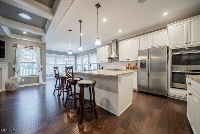4643 Pebble Creek Ct, Peninsula, OH 44264 - kitchen featuring appliances with stainless steel finishes, wall chimney range hood, dark wood finished floors, light stone countertops, and white cabinetry
