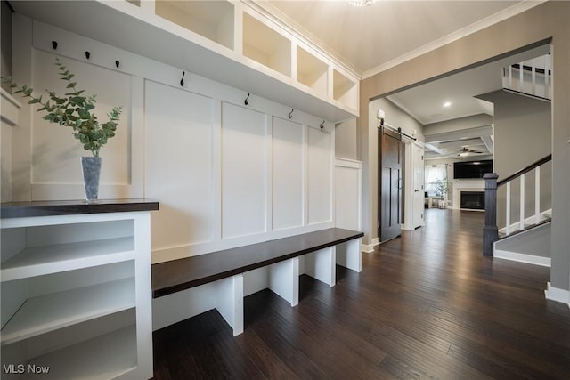 4643 Pebble Creek Ct, Peninsula, OH 44264 - mudroom featuring dark wood-style flooring, crown molding, a barn door, and a fireplace