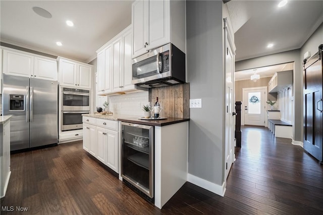 4643 Pebble Creek Ct, Peninsula, OH 44264 - kitchen featuring stainless steel appliances, beverage cooler, a barn door, dark wood finished floors, and recessed lighting