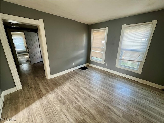 empty room featuring wood finished floors and baseboards