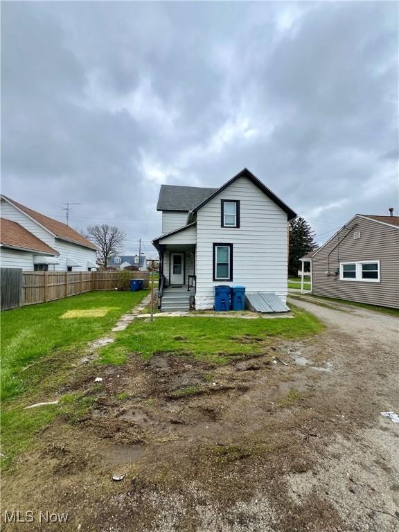 back of house featuring a yard and fence