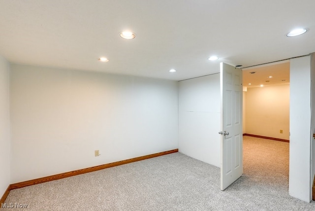 finished below grade area with baseboards, recessed lighting, and light colored carpet