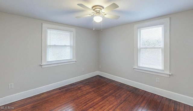 empty room with baseboards, a ceiling fan, and dark wood finished floors