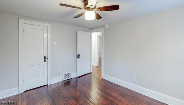 empty room featuring baseboards, wood-type flooring, a ceiling fan, and visible vents
