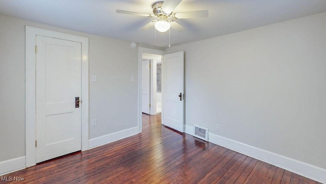 unfurnished bedroom featuring visible vents, baseboards, hardwood / wood-style floors, and a ceiling fan