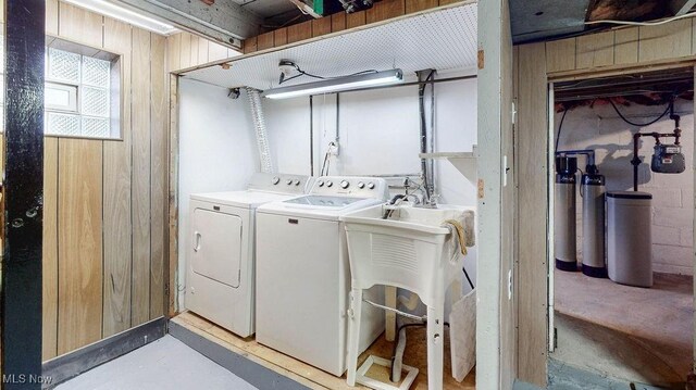 washroom with separate washer and dryer and wooden walls
