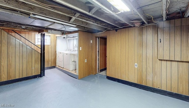 below grade area featuring wood walls and washer and clothes dryer