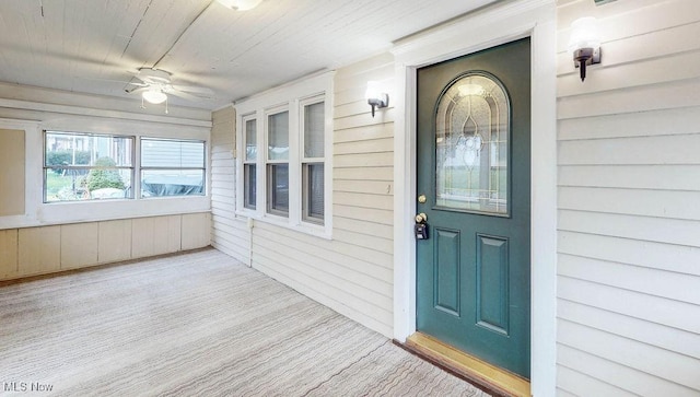 view of exterior entry with a porch and a ceiling fan