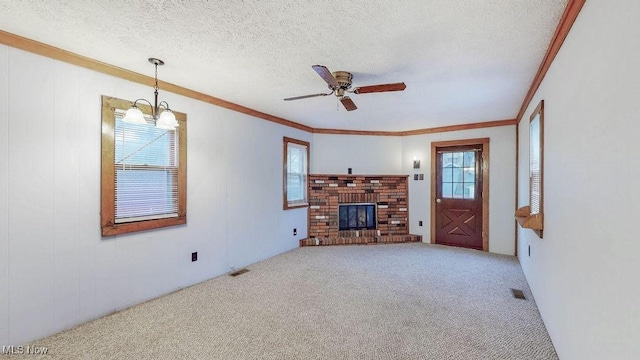 unfurnished living room with ornamental molding, a fireplace, carpet flooring, a ceiling fan, and visible vents