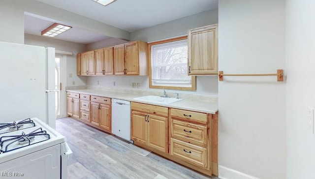 kitchen with light brown cabinets, white appliances, light countertops, light wood finished floors, and a sink