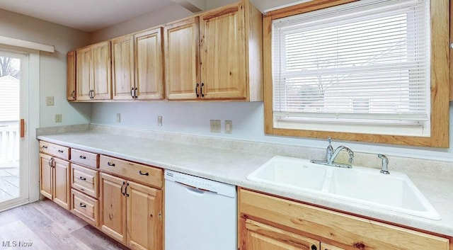 kitchen featuring light wood-style flooring, light countertops, white dishwasher, a sink, and light brown cabinetry