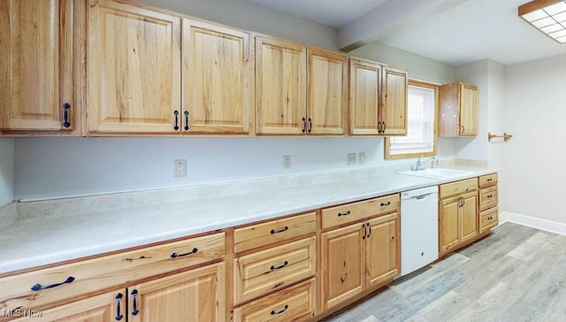 kitchen featuring dishwasher, light brown cabinets, and a sink
