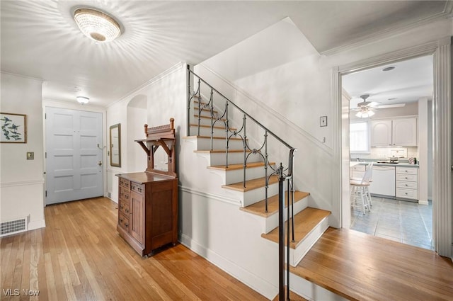 2691 Rocklyn Rd, Shaker Heights, OH 44122 - staircase with ceiling fan, arched walkways, visible vents, hardwood / wood-style floors, and baseboards