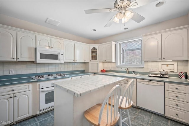 2691 Rocklyn Rd, Shaker Heights, OH 44122 - kitchen featuring tile countertops, white appliances, visible vents, a sink, and backsplash