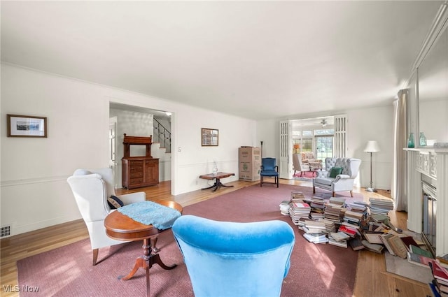 2691 Rocklyn Rd, Shaker Heights, OH 44122 - living room with visible vents, ceiling fan, stairway, wood finished floors, and a glass covered fireplace