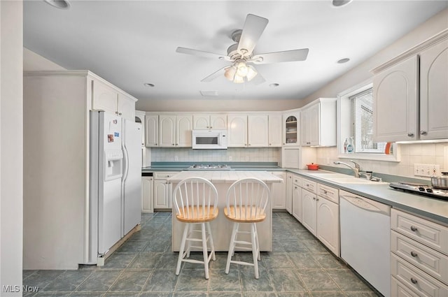 2691 Rocklyn Rd, Shaker Heights, OH 44122 - kitchen with white appliances, tasteful backsplash, a ceiling fan, a kitchen island, and a sink