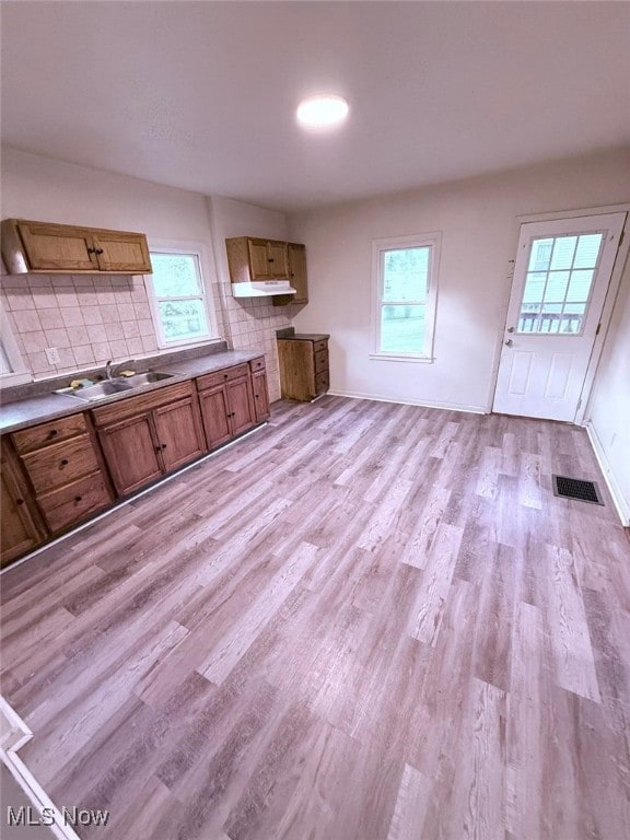 270 Coitsville Rd, Campbell, OH 44405 - kitchen featuring brown cabinets, plenty of natural light, light wood-style flooring, and tasteful backsplash