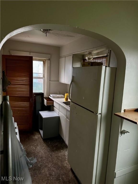 471 W Hylda, Youngstown, OH 44511 - kitchen featuring arched walkways, freestanding refrigerator, light countertops, and white cabinetry