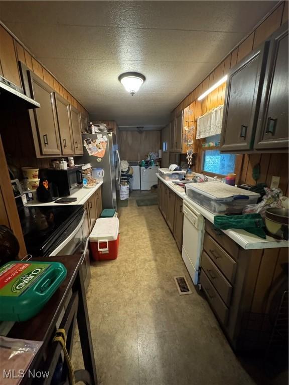 1110 3rd St, Belpre, OH 45714 - kitchen featuring washer and clothes dryer, black appliances, and light countertops