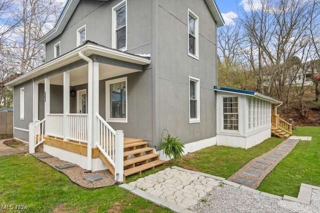 back of house featuring a porch and a lawn
